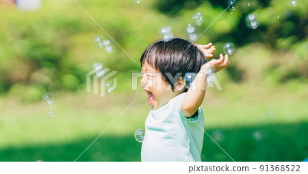 A one and a half year old boy who is pleased with soap bubbles 91368522