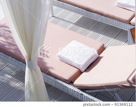 A rattan couch with a soft mattress and a snow-white towel folded on it. South Beach Vacation A rattan couch with a soft mattress and a snow-white towel folded on it. South Beach Vacation 91369112