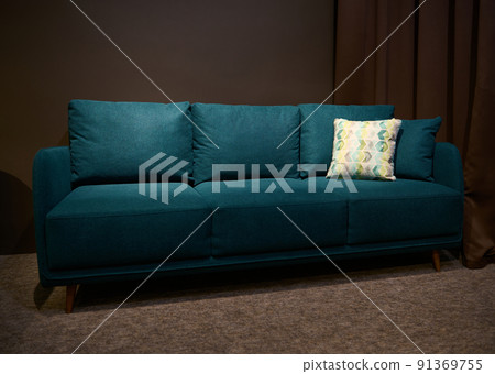 Stylish green sofa bed with green and beige cushion displayed for sale in the upholstered furniture design showroom Stylish green sofa bed with green and beige cushion displayed for sale in the upholstered furniture design showroom 91369755