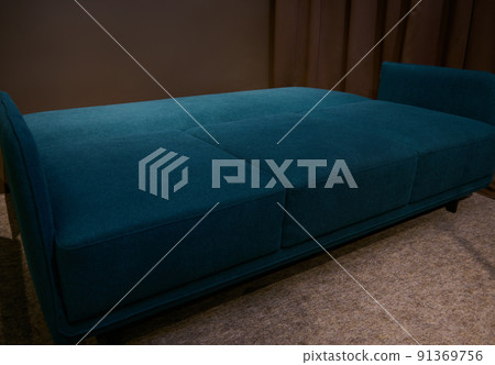 Minimalist comfortable and orthopedic dark blue and green sofa bed in a folding form, on display in a furniture store. Home interior design concept Minimalist comfortable and orthopedic dark blue and green sofa bed in a folding form, on display in a furniture store. Home interior design concept 91369756