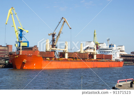Coal is loaded on a dry cargo ship in a docked port. 91371523