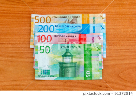 Banknotes of the Norwegian krone on wooden table. 91372814