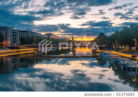 Sunrise view on Aura (Aurajoki) river with bridge and Turku Cathedral in the background in Turku, Finland. Sunrise view on Aura (Aurajoki) river with bridge and Turku Cathedral in the background in Turku, Finland. 91373085