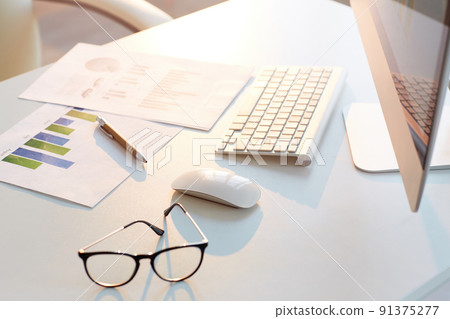 Close-up of business papers with graphs and charts placed on desk with computer, eyeglasses and pen, background Close-up of business papers with graphs and charts placed on desk with computer, eyeglasses and pen, background 91375277