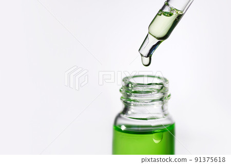 Pipette with transparent fluid hyaluronic acid or serum. Cosmetics, science and healthcare concept closeup. Dose of serum or retinol falls in a bottle. Front view. Beauty product presentation, macro Pipette with transparent fluid hyaluronic acid or serum. Cosmetics, science and healthcare concept closeup. Dose of serum or retinol falls in a bottle. Front view. Beauty product presentation, macro 91375618