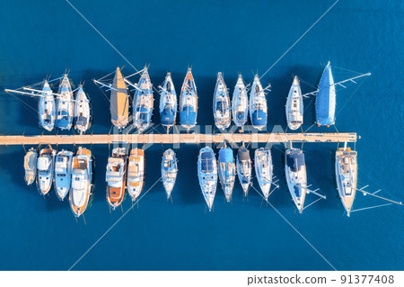 Aerial view of boats and yachts in dock at sunset in summer Aerial view of boats and yachts in dock at sunset in summer 91377408