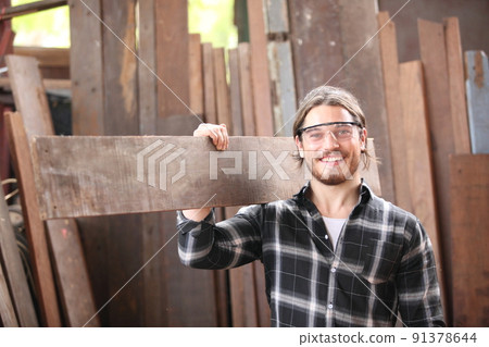 Carpenter working on woodworking machines in carpentry shop. he works in a carpentry shop or warehouse 91378644