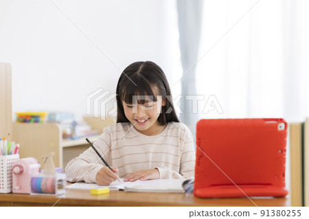 Girl elementary school student studying on a tablet PC 91380255