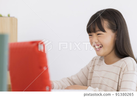 Girl elementary school student studying on a tablet PC 91380265