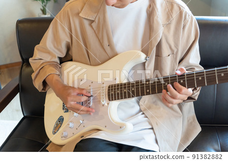 Young man playing white electric guitar 91382882