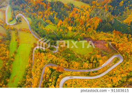 Picturesque autumn landscape with road between the hills.  91383615
