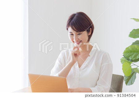 A smiling woman who operates a personal computer 91384504