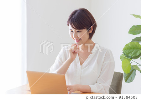 A smiling woman who operates a personal computer 91384505