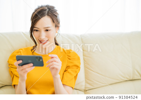一位年輕女子在智能手機上享受網上購物 一位年輕女子在智能手機上享受網上購物 91384524