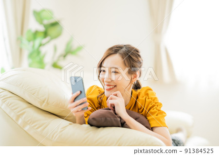 一位年輕女子在智能手機上享受網上購物 一位年輕女子在智能手機上享受網上購物 91384525