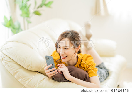 一位年輕女子在智能手機上享受網上購物 91384526