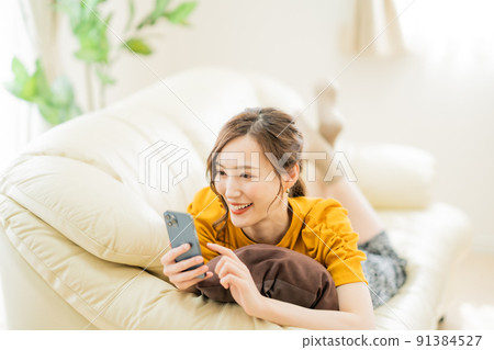 一位年輕女子在智能手機上享受網上購物 91384527