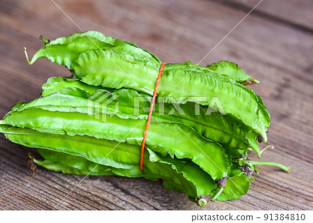Winged Bean on wooden background, Psophocarpus tetragonolobus - Green winged or Four angle beans 91384810