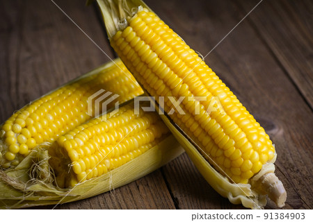 sweet corn cooked on wooden background, ripe corn cobs steamed or boiled sweetcorn for food vegan dinner or snack 91384903