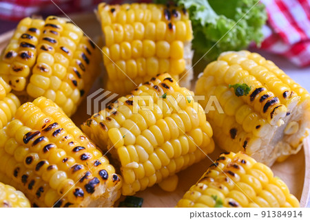 sweet corn food with salad vegetable lime coriander and lettuce, sweet corn cooked on plate background, ripe corn cobs grilled sweetcorn for food vegan dinner or snack 91384914
