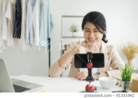 Businesswoman giving important pieces of advice while streaming video for women's clothing. 91385962