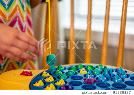Children's game of using a miniature pole and line lowered into open plastic fish to catch them as the pond spins.  91389387