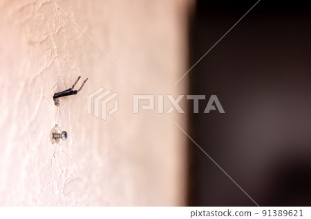 Selective focus on hole in a residential wall with two wires sticking out for surround sound speakers. Selective focus on hole in a residential wall with two wires sticking out for surround sound speakers. 91389621