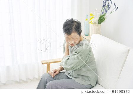 Elderly woman feeling stiff shoulders at home Elderly woman feeling stiff shoulders at home 91390573