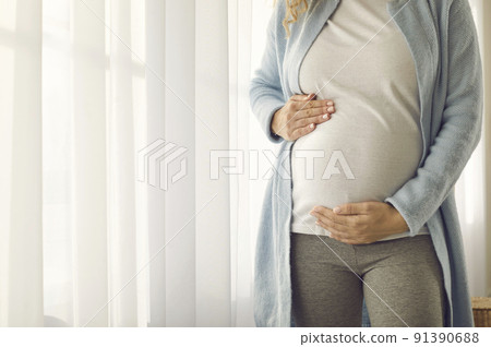 Tummy of pregnant woman who gently supports him with her hands in anticipation of meeting baby. Tummy of pregnant woman who gently supports him with her hands in anticipation of meeting baby. 91390688