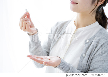 A woman drinking supplements A woman drinking supplements 91390755