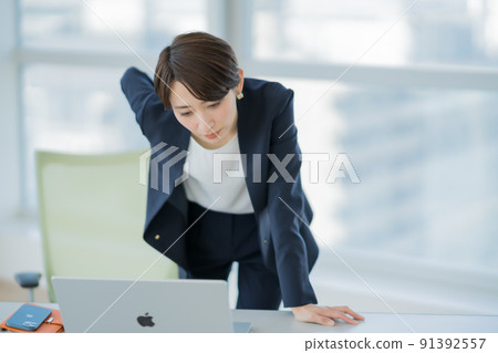A woman staring at a busy computer while standing 91392557