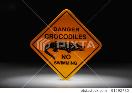 Danger crocodiles no swimming sign in the dramatic light Danger crocodiles no swimming sign in the dramatic light 91392780