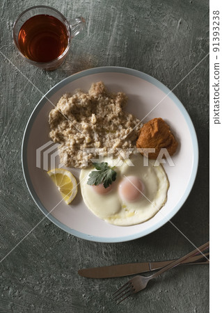 Healthy breakfast oatmeal and fried eggs Healthy breakfast oatmeal and fried eggs 91393238