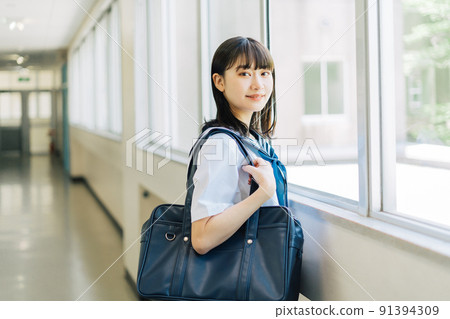 High school girl standing in the school corridor 91394309