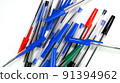 A lot of colorful ballpoint pens spinning on white screen in office or school. Top view. Selective focus. 91394962