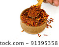 Chef taking spices paprika or chili flakes from wooden spice jar. 91395358
