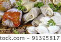 Frozen semi-finished products, stuffed bell peppers, cabbage rolls and dumplings lies on counter in market or on table in the home kitchen. Dolly shot. Close-up. 91395817