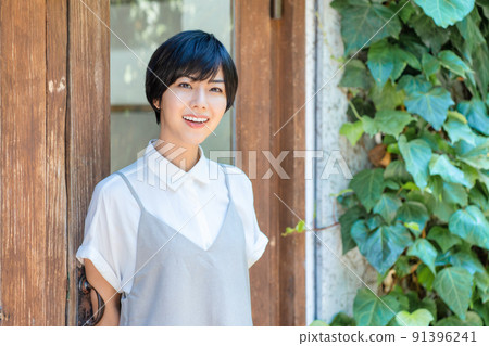 A smiling young woman relaxing on the terrace 91396241