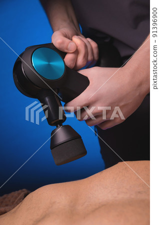 Sports percussion massage in the medical office of the gym. The masseur makes massage exercises. Percussion therapy for regenerating sports body massage. Sports injury rehabilitation concepts. Sports percussion massage in the medical office of the gym. The masseur makes massage exercises. Percussion therapy for regenerating sports body massage. Sports injury rehabilitation concepts. 91396900