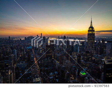 High rise buildings in arranged in blocks surrounded with streets. Cityscape against colourful sunset sky. Manhattan, New York City, USA 91397563