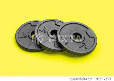 Black weight plates on green background. Gym equipment 91397645