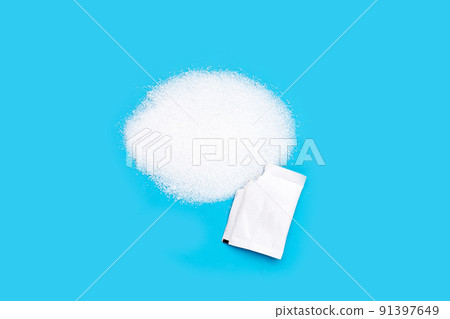 Granulated sugar with sugar sachet on blue background. Granulated sugar with sugar sachet on blue background. 91397649