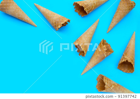 Empty ice cream cone on blue background. 91397742