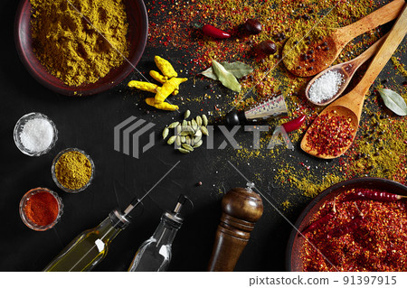 Set of indian spices on black background - green cardamom, turmeric powder, coriander seeds, cumin, and chili, top view Set of indian spices on black background - green cardamom, turmeric powder, coriander seeds, cumin, and chili, top view 91397915