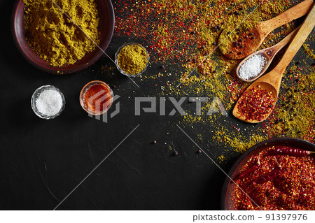 Set of indian spices on black background - green cardamom, turmeric powder, coriander seeds, cumin, and chili, top view 91397976