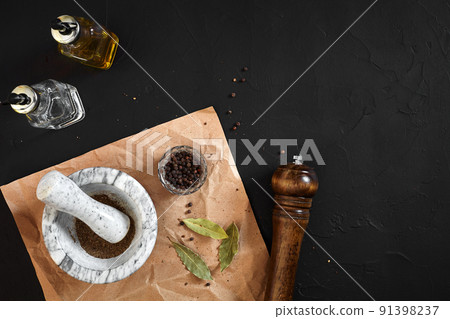 White mortar and pestle with dried peppers in flat lay on black background White mortar and pestle with dried peppers in flat lay on black background 91398237