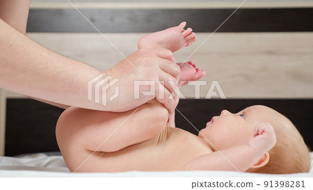 Grandmother does leg exercise with newborn baby girl on bed Grandmother does leg exercise with newborn baby girl on bed 91398281