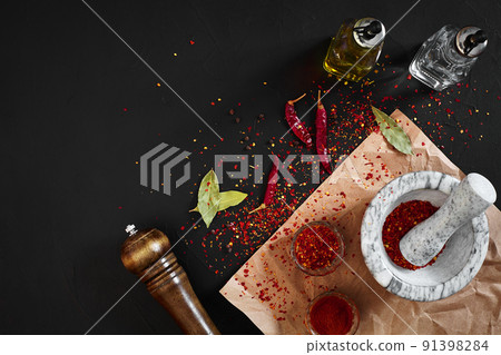 Dried and crushed red chili pepper in stone mortar. Copy space 91398284