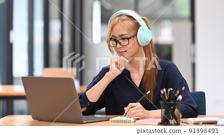 Young female employee watching webinar, communicating by conference video call on laptop computer Young female employee watching webinar, communicating by conference video call on laptop computer 91398491