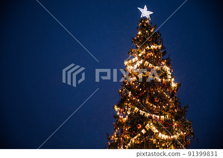 Christmas tree with lights of garland for the new year 91399831